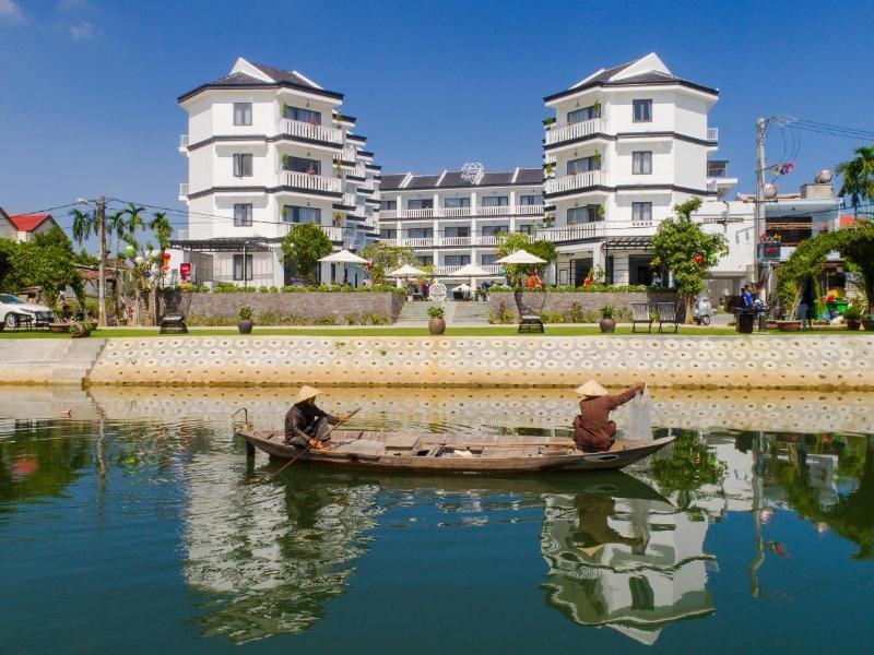 Nhân viên khách sạn mặc những bộ bà ba dân dã, chèo thuyền trên sông