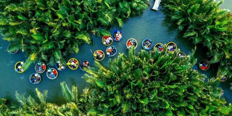 Visitors trying the Basket Boat Dance at Bay Mau Coconut Forest
